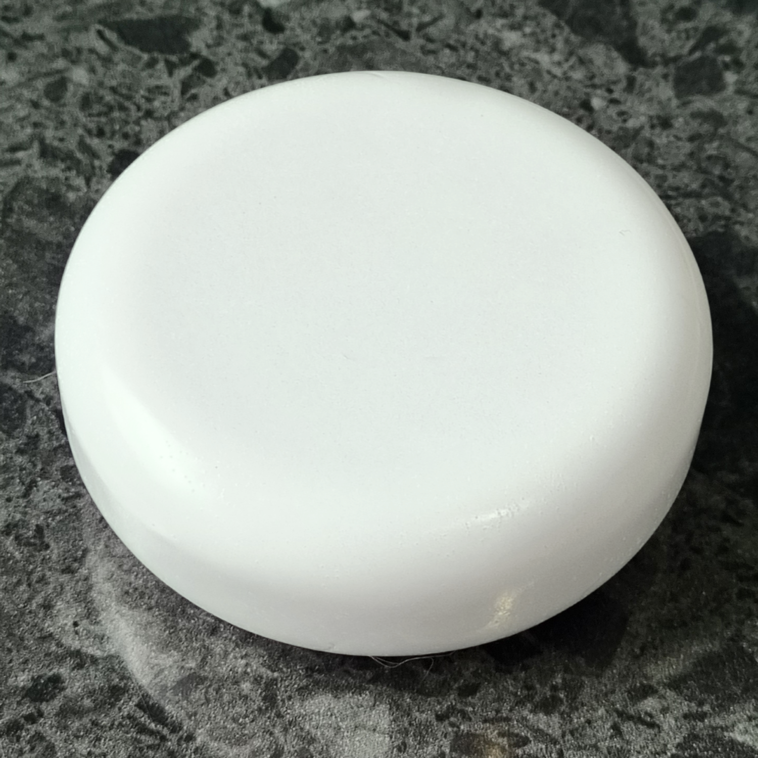 White tea scented round soap on stone surface